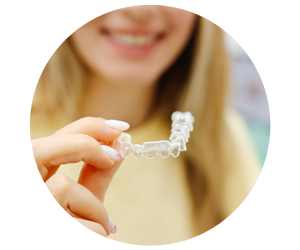 close up of smiling teen holding clear aligner